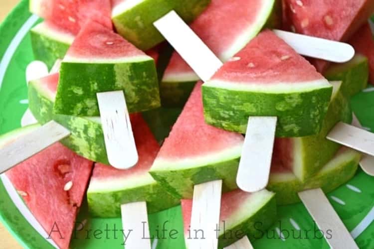 Watermelon slices placed on popsicle sticks