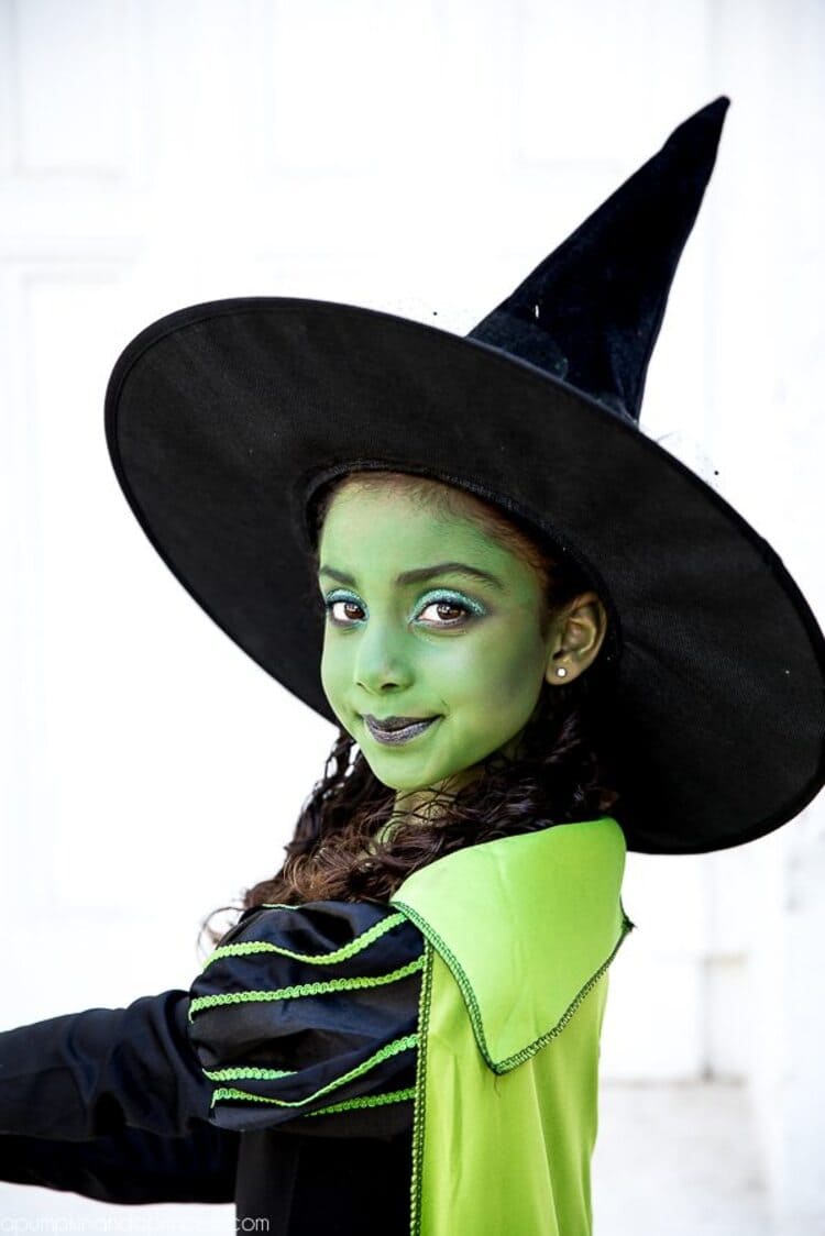 girls dressed as a wicket witch with green face paint