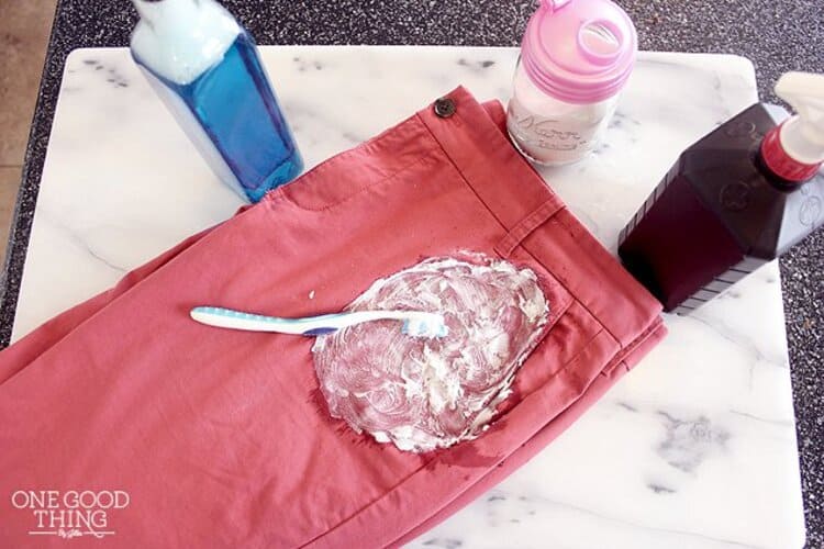 diy cleaning paste for oil stains scrubbed with toothbrush on red jeans