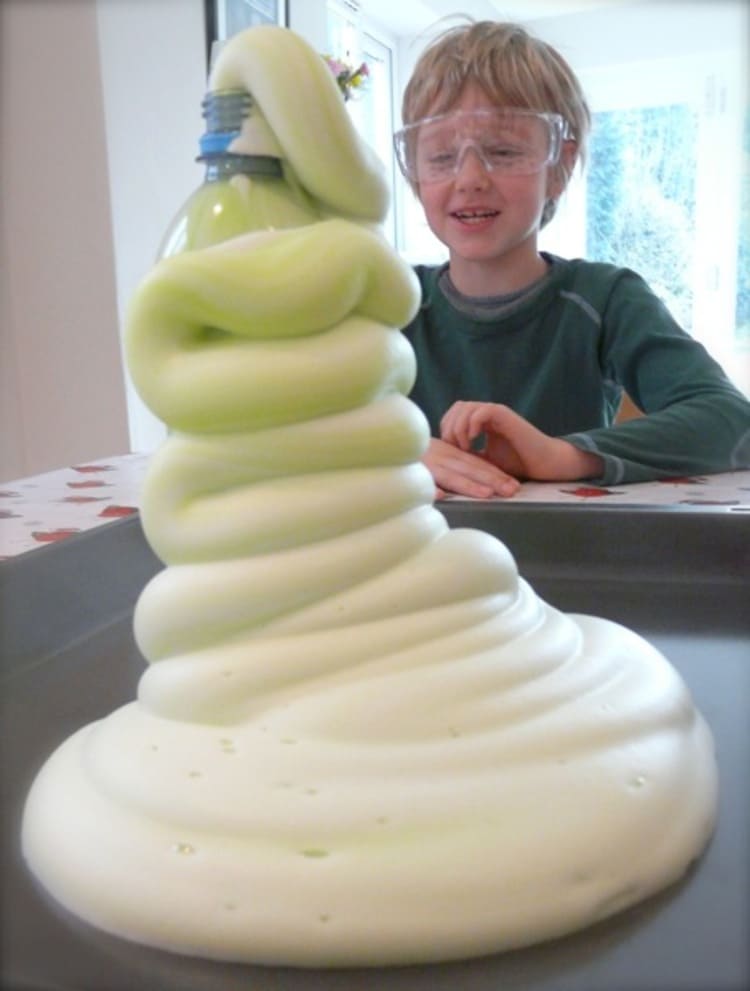 elephant toothpaste experiment and a child with safety goggles behind it