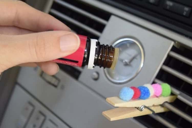 essential oils and cotton balls clipped to air vent for a better smelling car